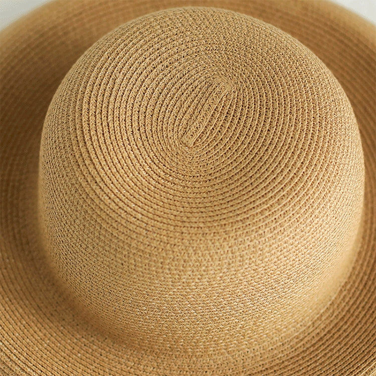 Close-up of beige woven straw hat crown with spiral stitch texture