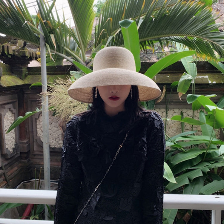 Light gray straw sun hat with wide brim and curved crown on a model