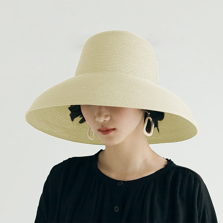 Light beige straw sun hat with wide brim and curved crown on a model