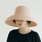 Light tan straw sun hat with wide brim and curved crown on a model