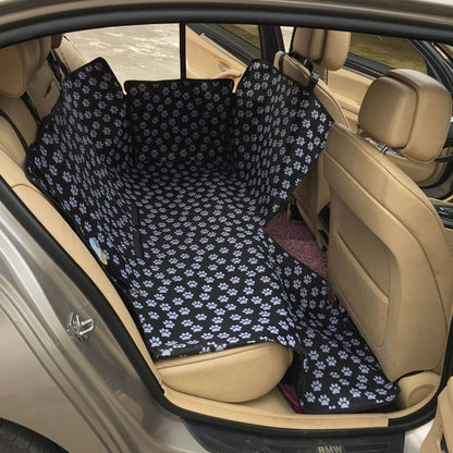 Black pet car seat cover hammock with white paw pattern and side straps