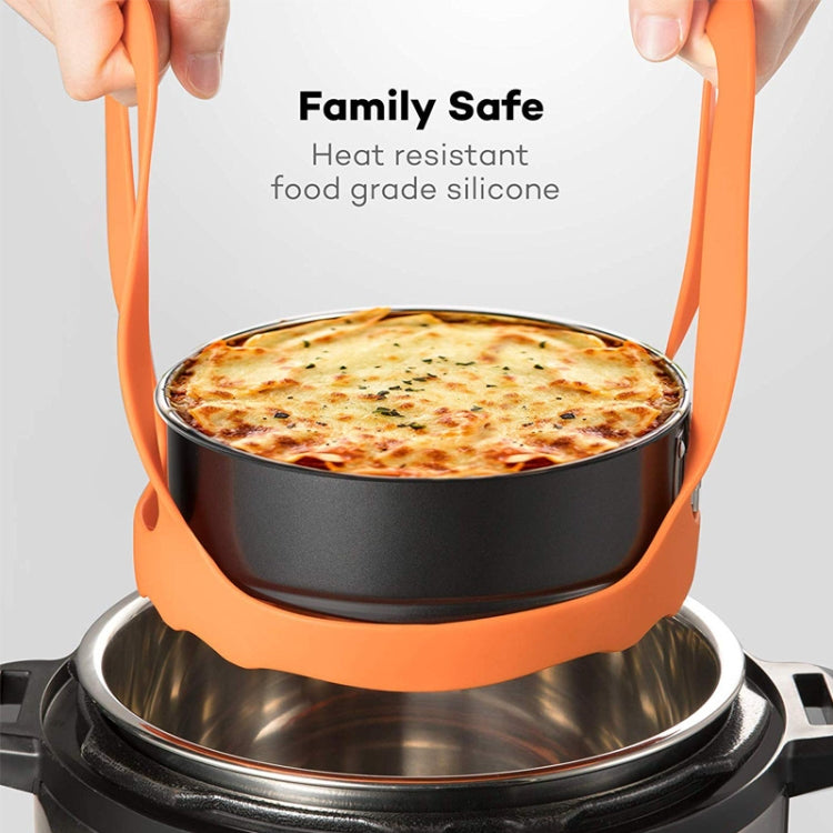 Orange silicone steamer egg cooker basket holding a steamer pot with side handles