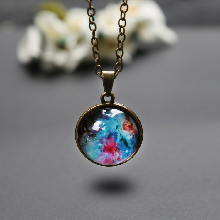 Round galaxy globe pendant hanging from gold chain, close-up