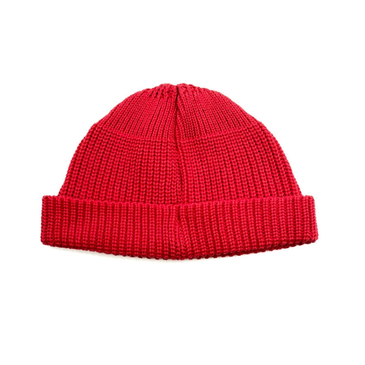 Red knitted beanie hat with ribbed brim and pom top, one-size, branded label.