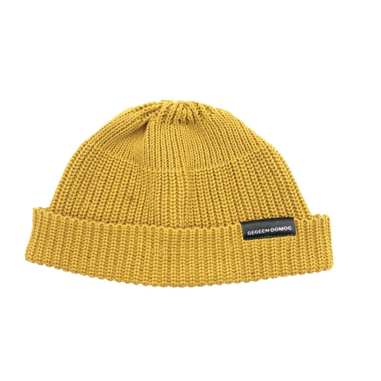 Yellow knitted beanie hat with ribbed brim and pom top, one-size, branded label.