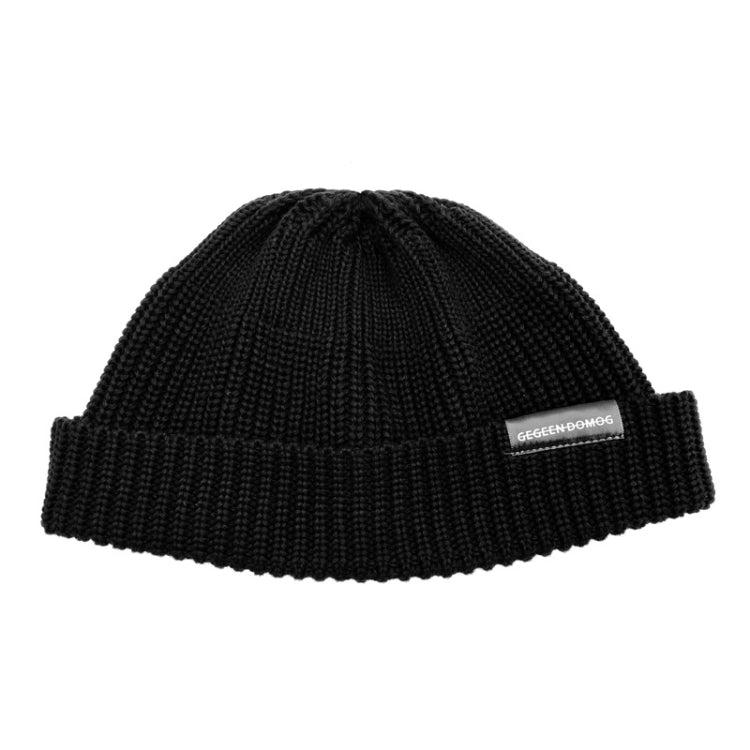 Black knitted beanie hat with ribbed brim and pom top, one-size, branded label.