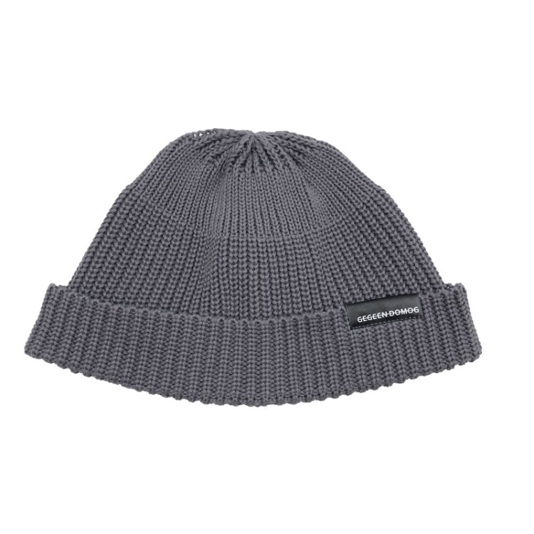 Gray knitted beanie hat with ribbed brim and pom top, one-size, branded label.