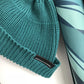Teal short knit beanie cuff with ribbed knit and rectangular logo label