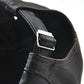 Close-up of black PU leather peaked cap side strap with metal buckle and stitch seam.