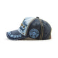 Casual baseball cap in navy with light blue panel, embroidered letters, and circular side patch.