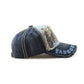 Casual baseball cap in dark denim with light blue side lettering and circular star patch details.