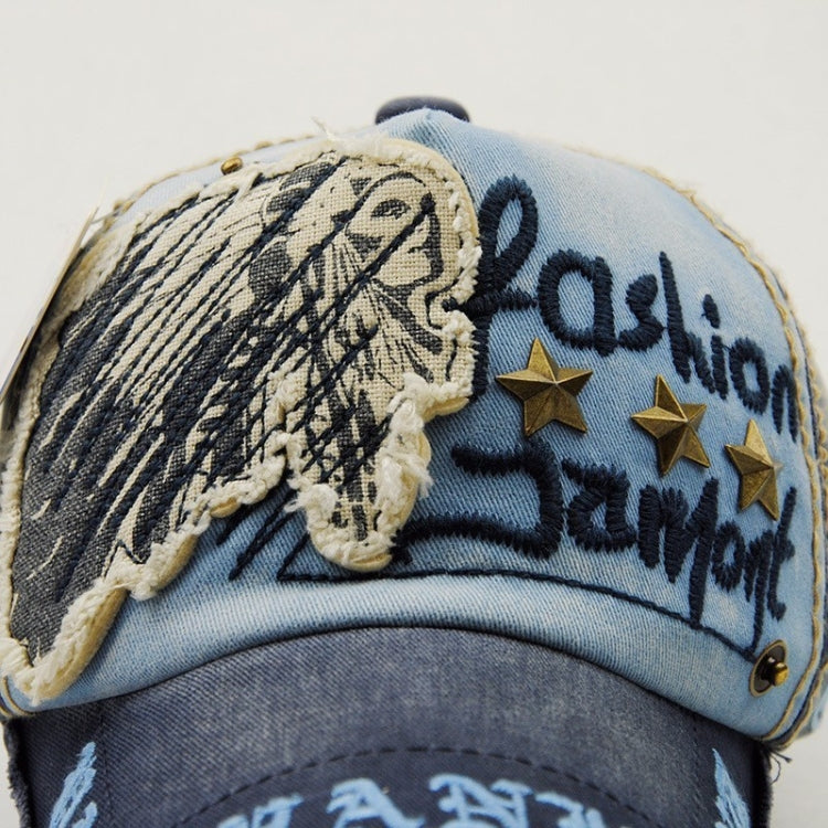 Close-up casual baseball cap in light blue and navy with embroidered face and star details.
