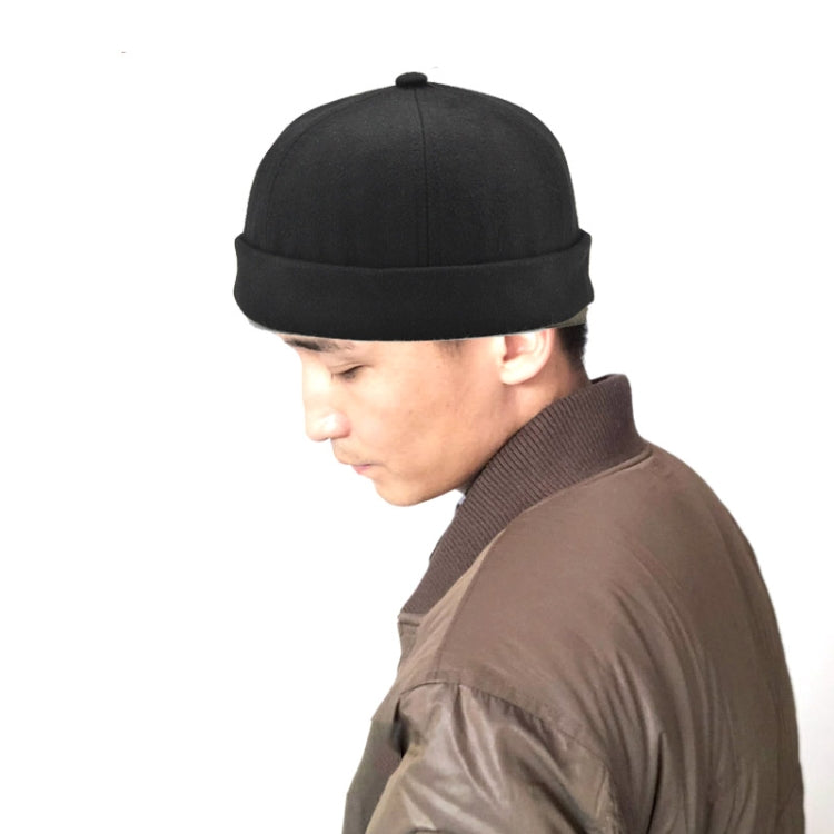 Black retro flanged landlord hat worn by person, no eaves, rounded crown.