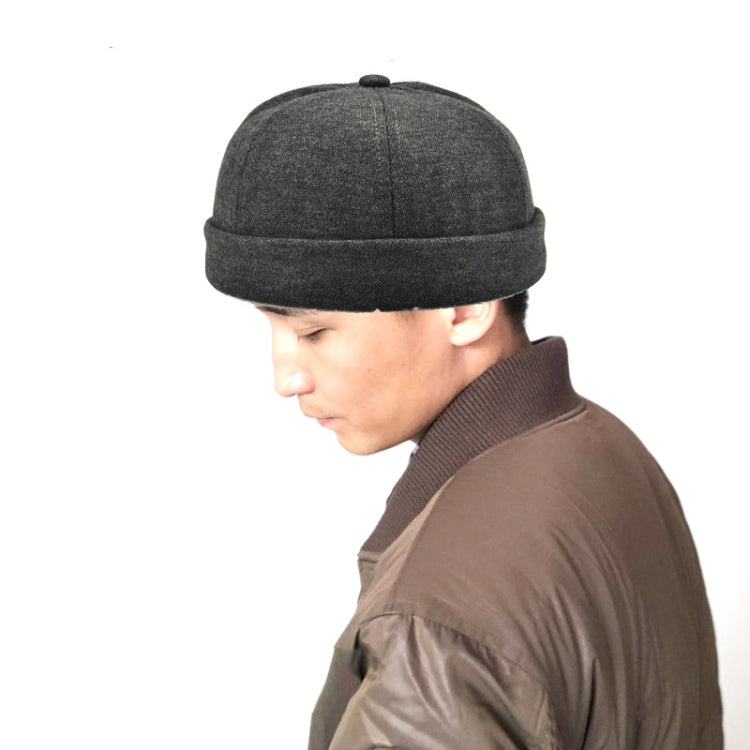 Dark gray retro flanged landlord hat worn by person, no eaves, rounded crown.