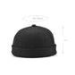 Black retro landlord skullcap hat with short flanged brim and rounded crown knob.