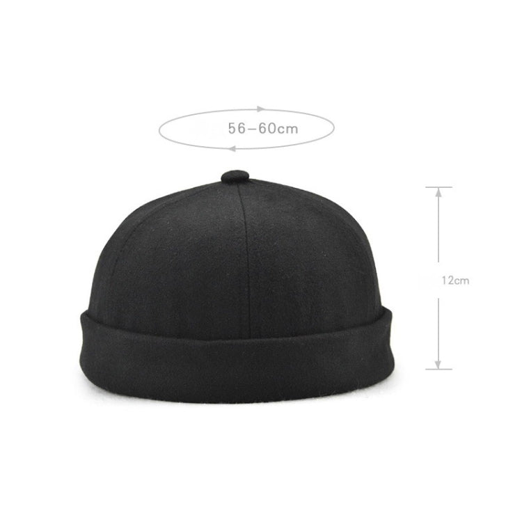 Black retro landlord skullcap hat with short flanged brim and rounded crown knob.