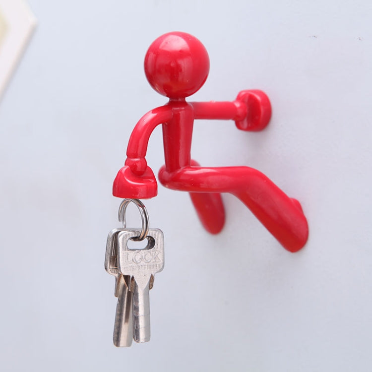 Red humanoid magnet key hanger holding a pair of metal keys.