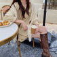 Cream knitted triangle shawl scarf with leather buckle strap and draped fit