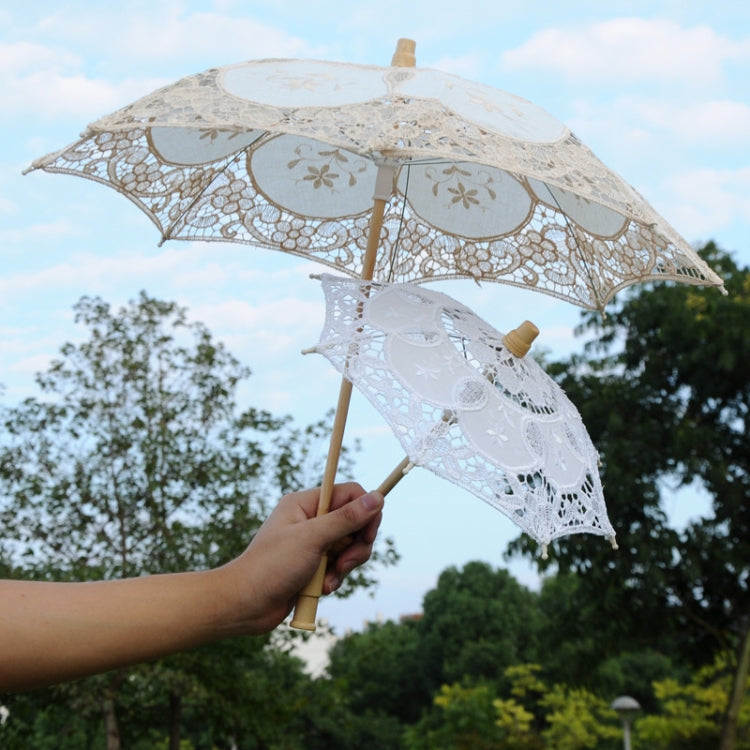 White lace parasol outdoors, scalloped canopy with floral lace panels