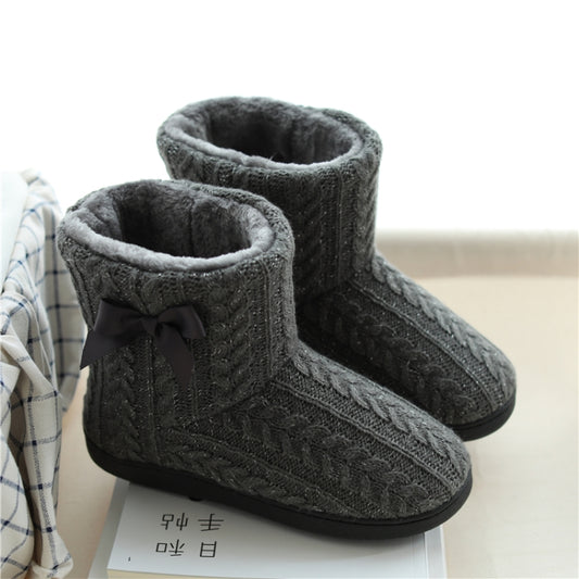 Dark gray cable-knit boot slippers with plush lining, dark bow, and thick black soles