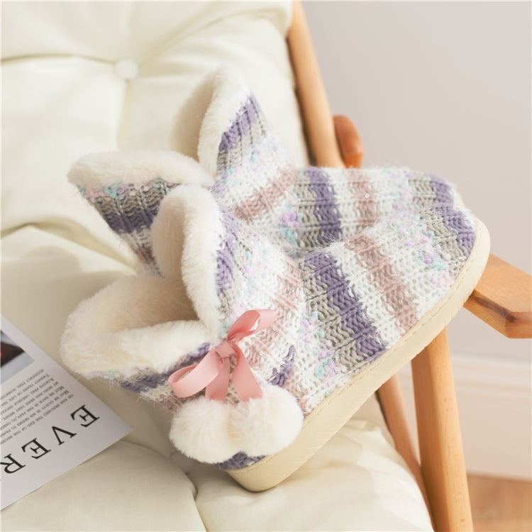 Close-up of multicolor knit home boot slippers with fluffy cuff and pink bow