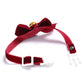 Red velvet bow pet collar with adjustable buckle and dangling gold bell.