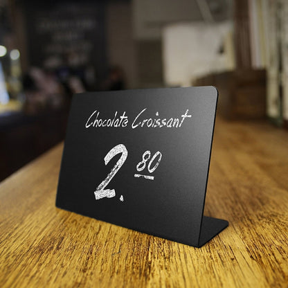 Small black desktop acrylic board with white menu text: Chocolate Croissant 2 80