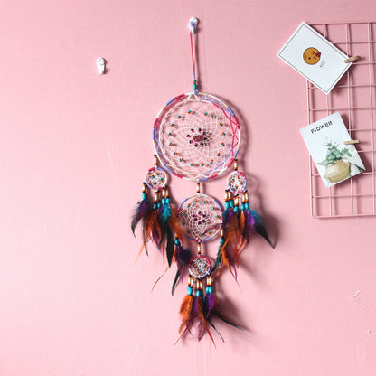 Colorful dream catcher wall hanging with woven rings, dangling feathers, and bead accents
