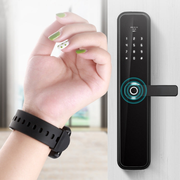 Black smart bracelet on wrist near a door lock keypad