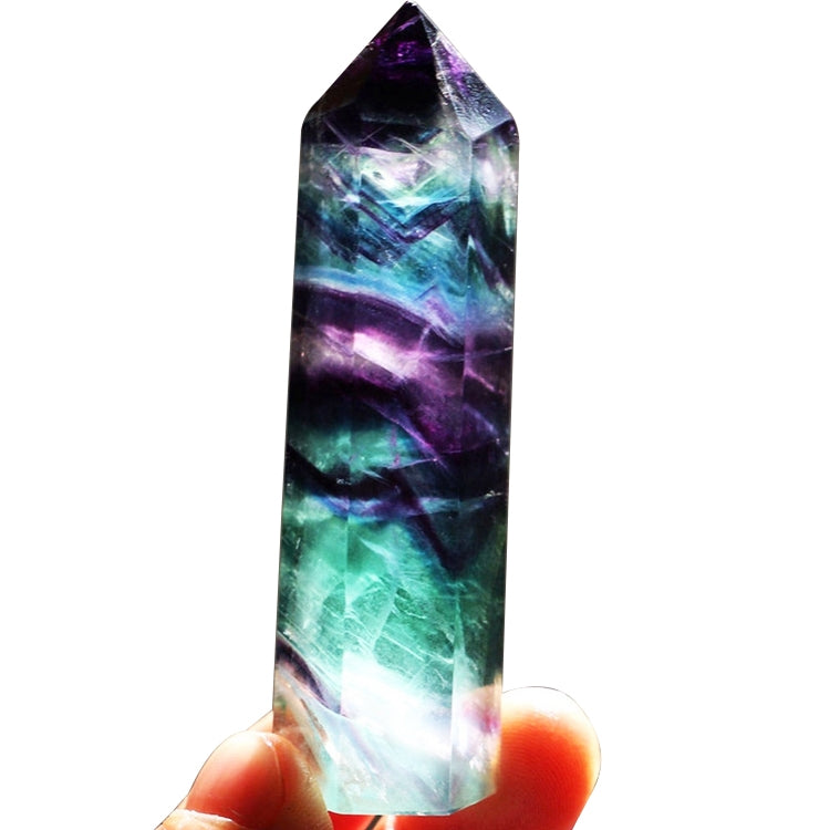 Multicolor fluorite crystal hexagonal column ornament with faceted top, held in hand