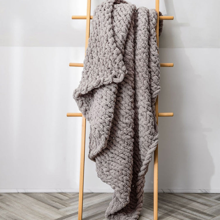 Thick knitted wool blanket, gray, draped over a stand with chunky texture