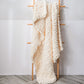 Thick knitted wool blanket, cream/ivory, draped over a stand with chunky knit