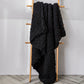 Thick knitted wool blanket, black, draped over a stand with chunky knit
