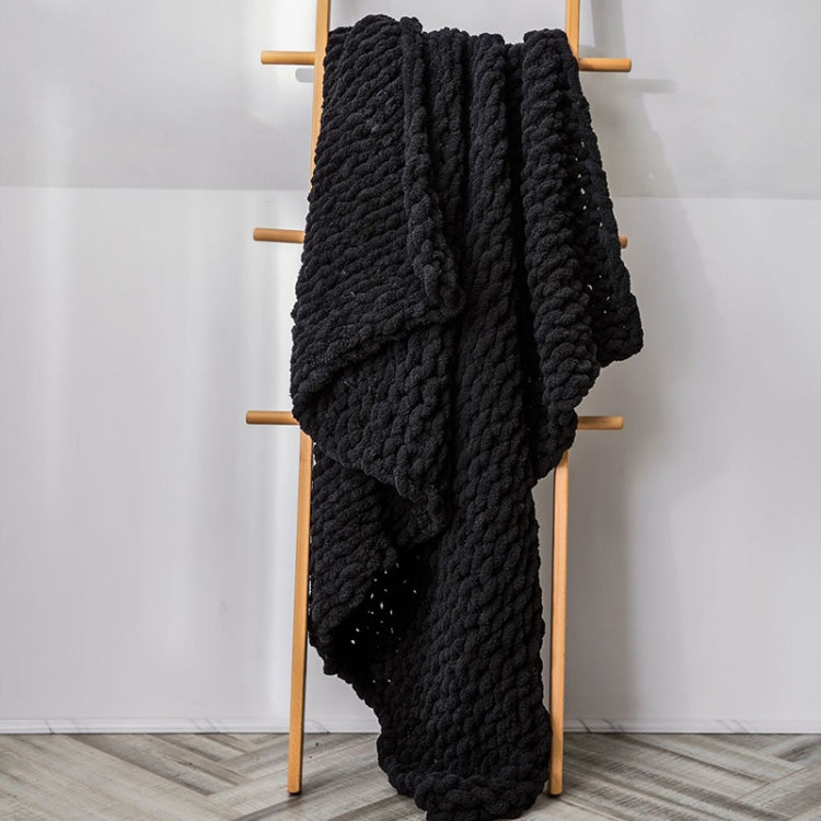 Thick knitted wool blanket, black, draped over a stand with chunky knit