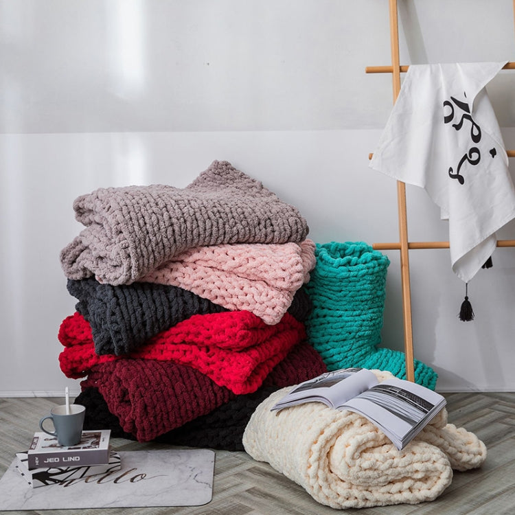 Folded chunky wool knit blankets in pink, gray, burgundy, teal, and dark gray