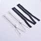 Group of zippers in white and silver tone, plus dark navy with gold-toned teeth