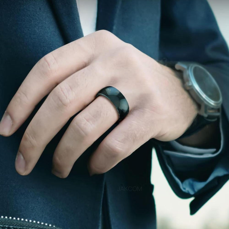 Smart ring worn on a hand with a dark green top