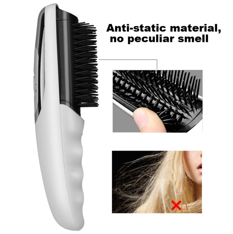 Silver electric massage comb with black bristles and side control button