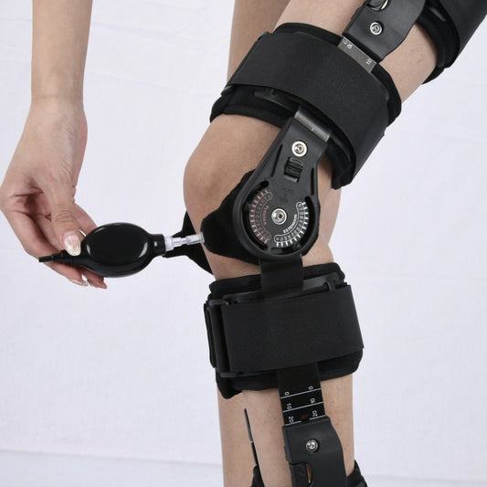 Black hinged knee brace with adjustable dial panel and stabilizing straps