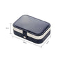 Portable jewelry storage box with rounded navy lid and snap clasp, cream sides