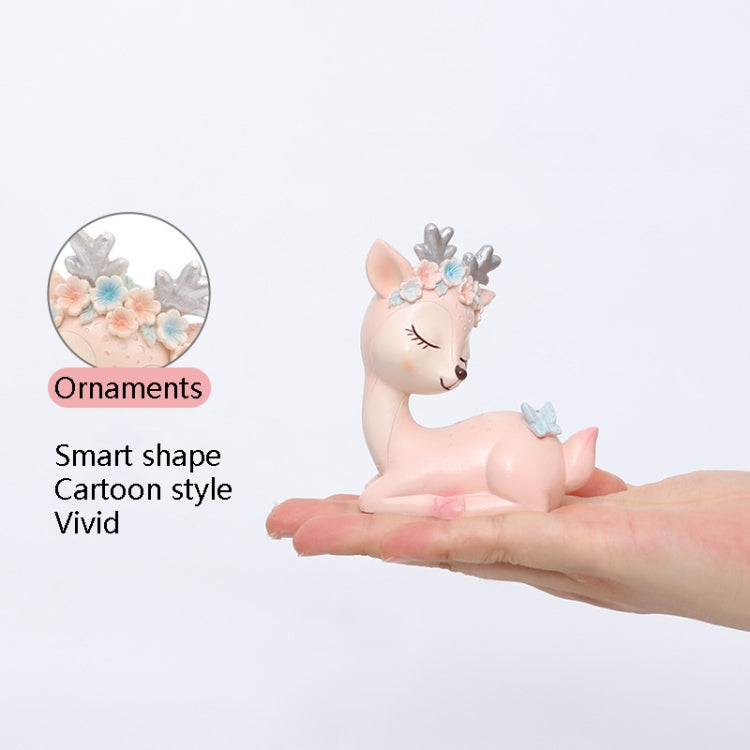 Cartoon deer resin ornaments in pink and blue on a hand, lying figures