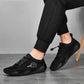 Black lace-up sneakers worn with black pants and low-profile rubber sole.