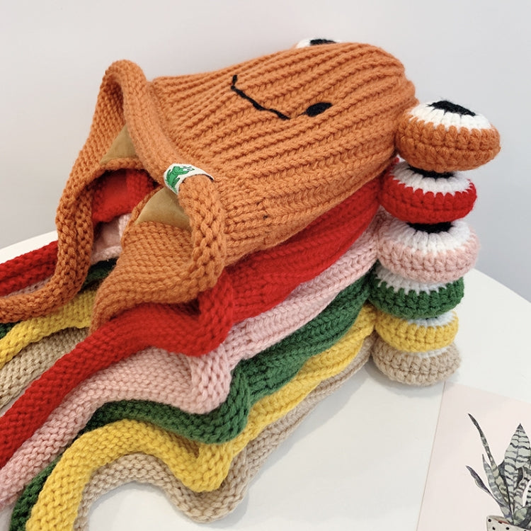 Stacked knitted frog hats in warm colors, each with smile face and big white-and-black eyes