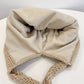 Beige knit winter hat with folded ear flaps and ribbed brim