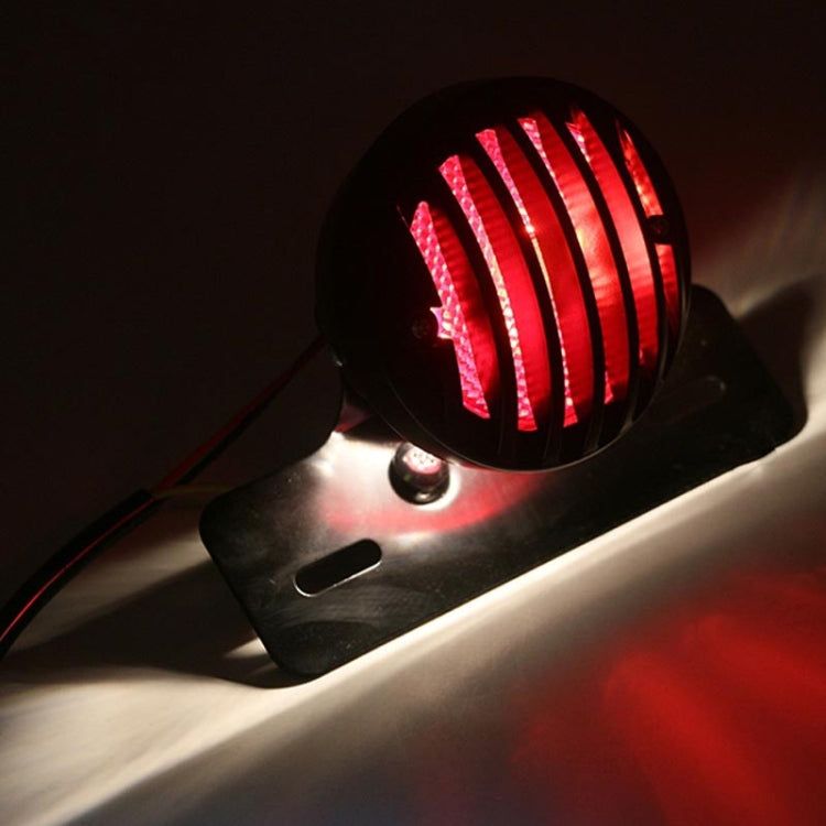Lit black tail light showing bright red LED stripe pattern on front lens