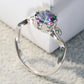 Close-up of sterling silver ring showing multicolor faceted gemstone and decorative setting prongs
