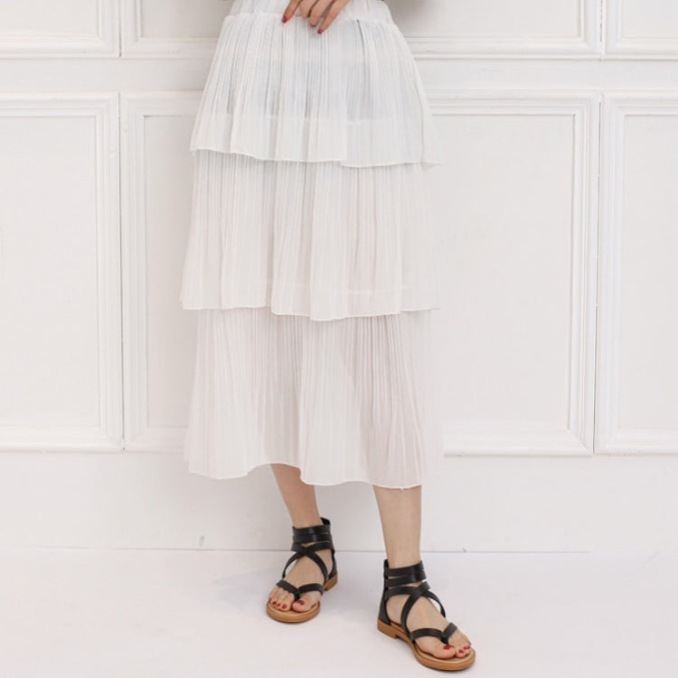 Black strappy low-heeled sandals worn with a white tiered dress