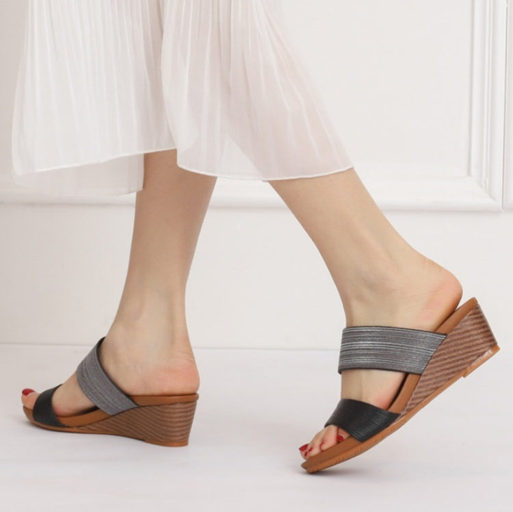 Two-strap platform wedge sandals on model, with dark grey straps and wood-look heel