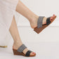 Two-strap wedge sandals with dark grey fabric straps and open toe, worn with white dress