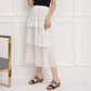Two-strap platform wedge sandals with dark grey straps worn with layered white skirt